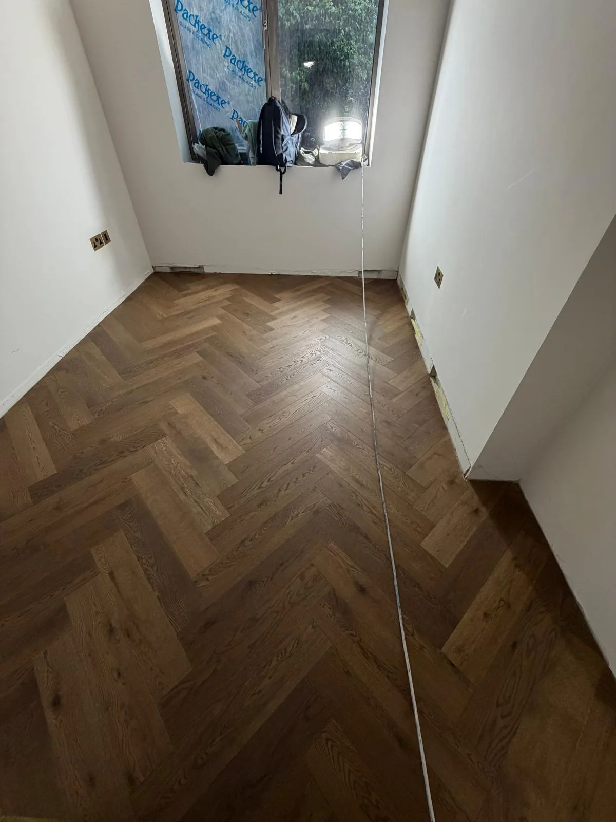 Finished engineered wood herringbone flooring, glued down