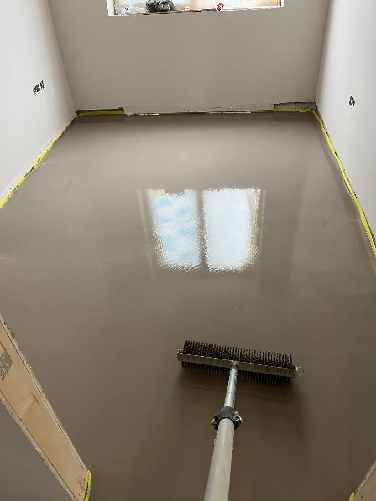 Self-levelling compound being applied during subfloor preparation